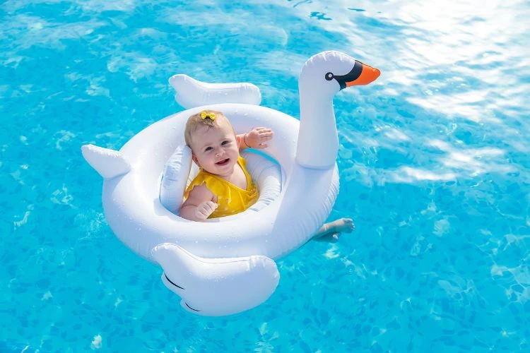 Beba pliva u vodi sa šlaufom.