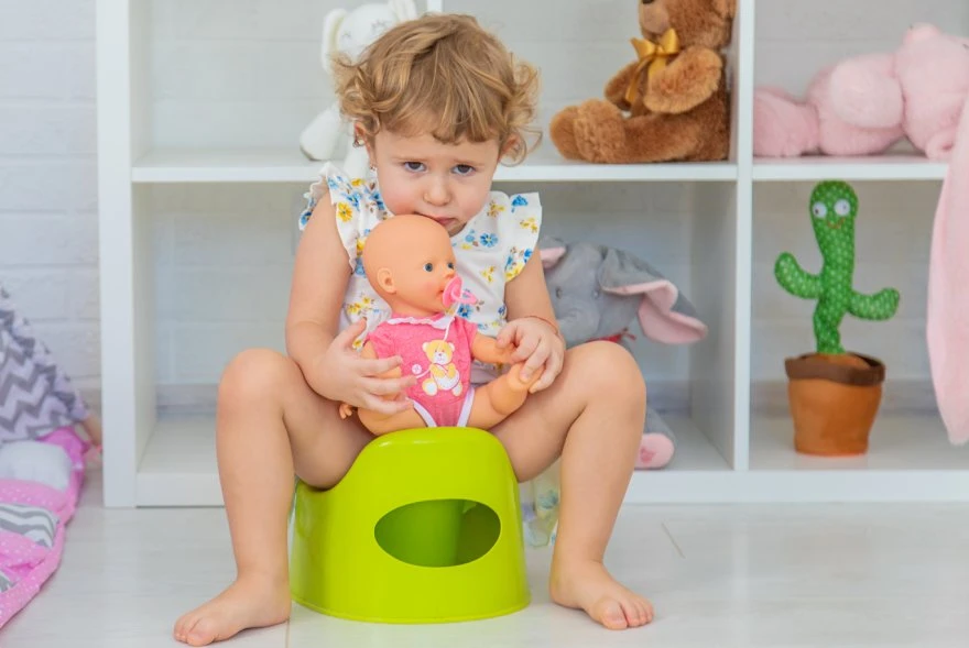 Dete sedi na noši sa lutkom